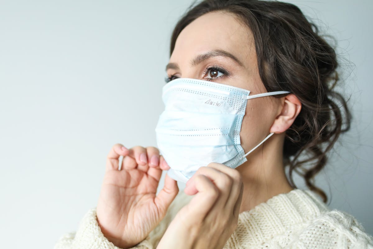 Healthcare worker in mask and clinical scrubs